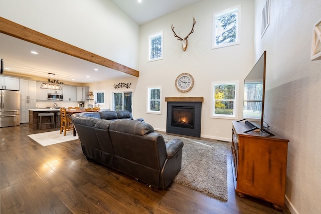 living room with beam ceiling, a towering ceiling, and dark hardwood / wood-style flooring