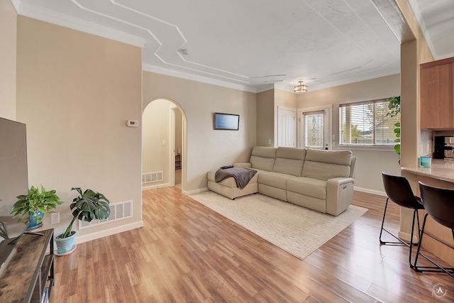 living room featuring crown molding and light hardwood / wood-style flooring