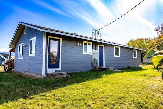 rear view of property featuring a yard