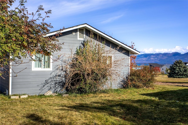 view of home's exterior featuring a lawn and a mountain view