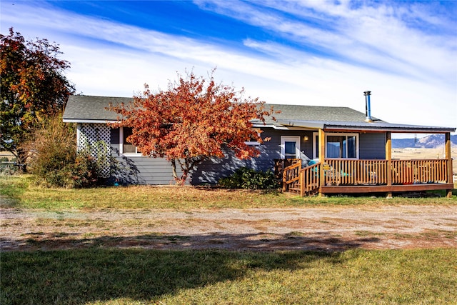 view of front of home with a front yard and a wooden deck