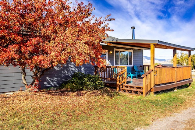 rear view of property with a yard and a wooden deck
