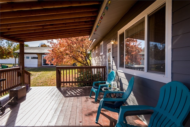 wooden terrace featuring a garage and an outdoor structure