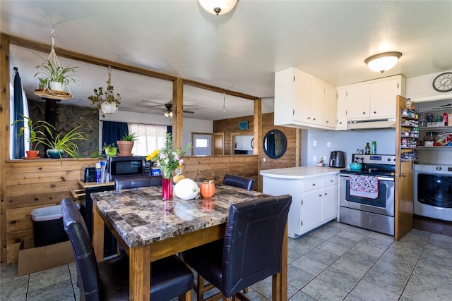 kitchen featuring white cabinetry, kitchen peninsula, washer / dryer, and stainless steel electric stove