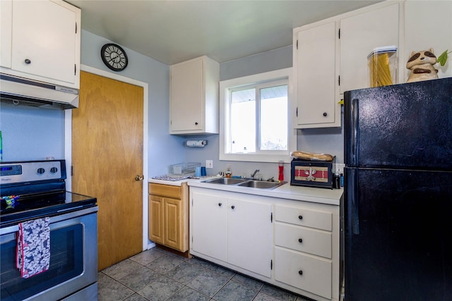 kitchen featuring exhaust hood, stainless steel electric range oven, a sink, light countertops, and freestanding refrigerator