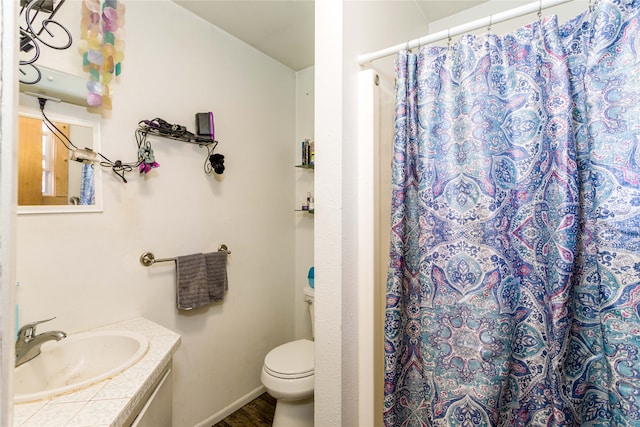 bathroom with toilet, vanity, and curtained shower