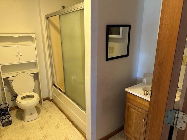bathroom with vanity, baseboards, tile patterned floors, toilet, and enclosed tub / shower combo