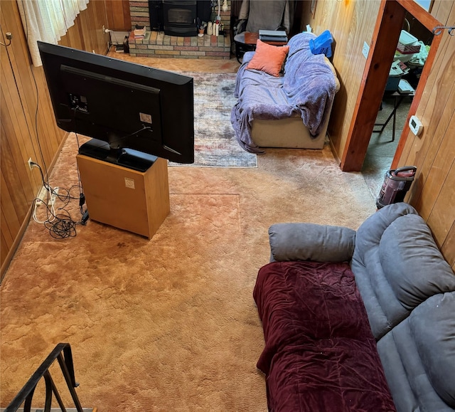 sitting room with light carpet, a wood stove, and wooden walls