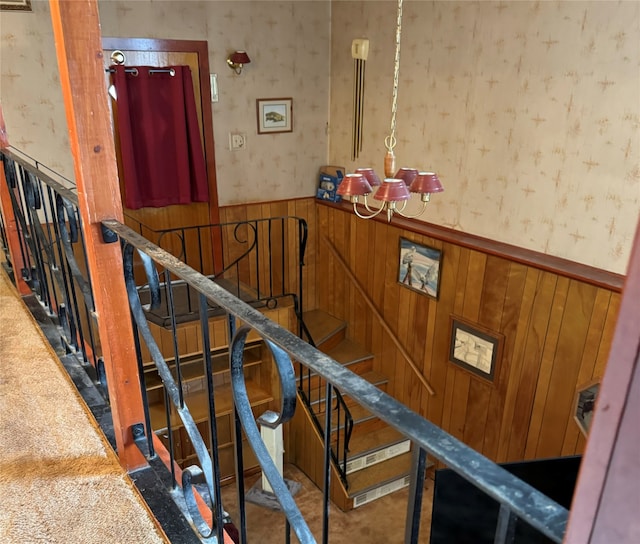 stairway with carpet floors and wooden walls