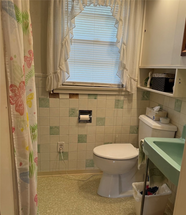 bathroom featuring toilet, tile walls, and a shower with curtain