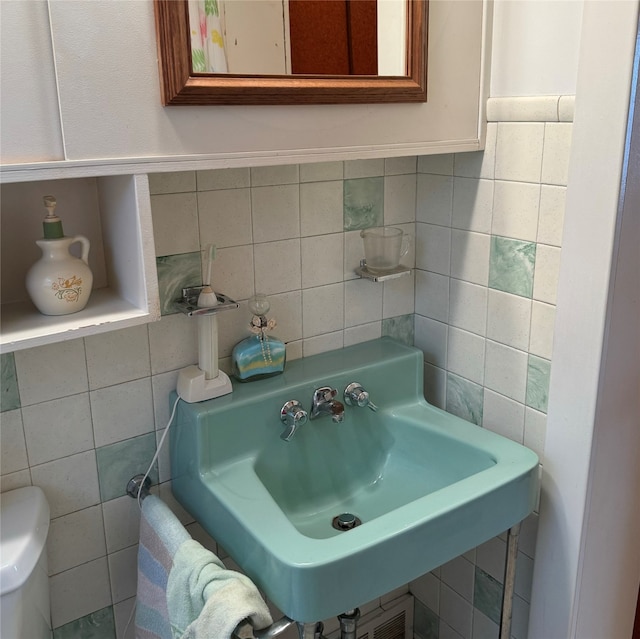 bathroom featuring backsplash, tile walls, sink, and toilet