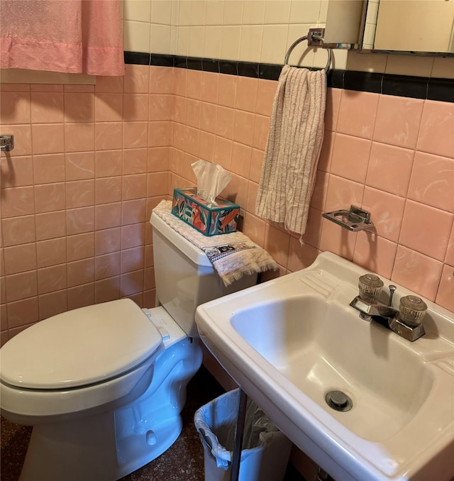 bathroom featuring toilet, decorative backsplash, sink, and tile walls