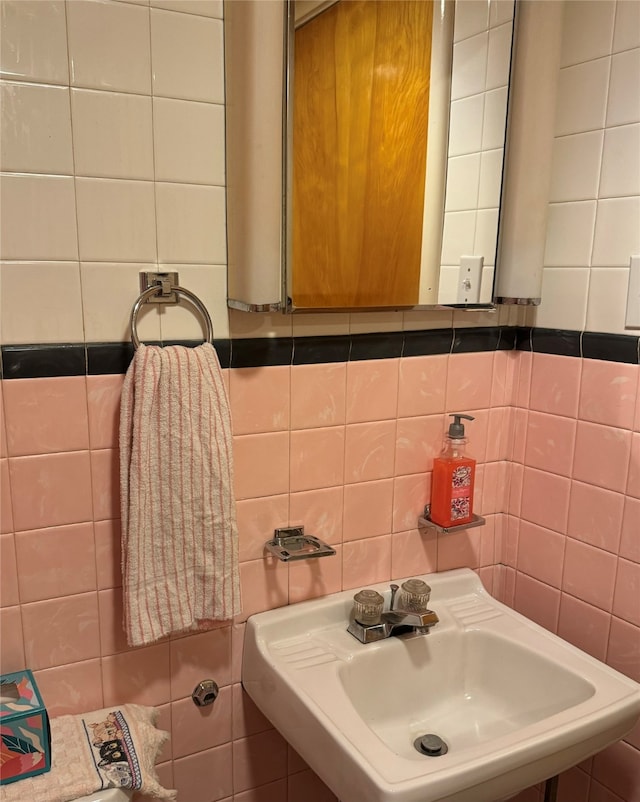 bathroom featuring decorative backsplash, sink, and tile walls