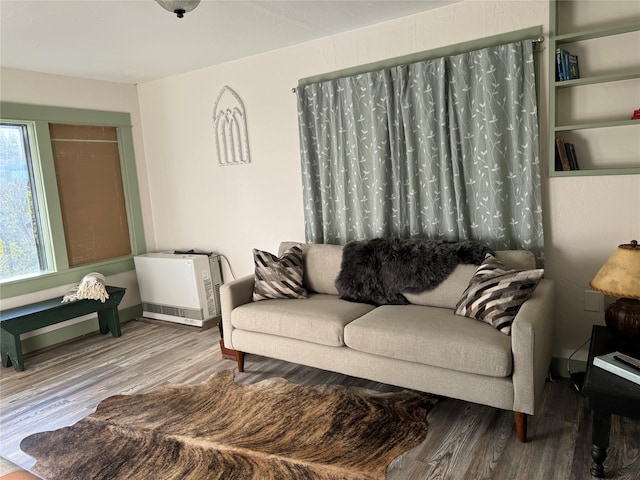 living room with hardwood / wood-style flooring and heating unit