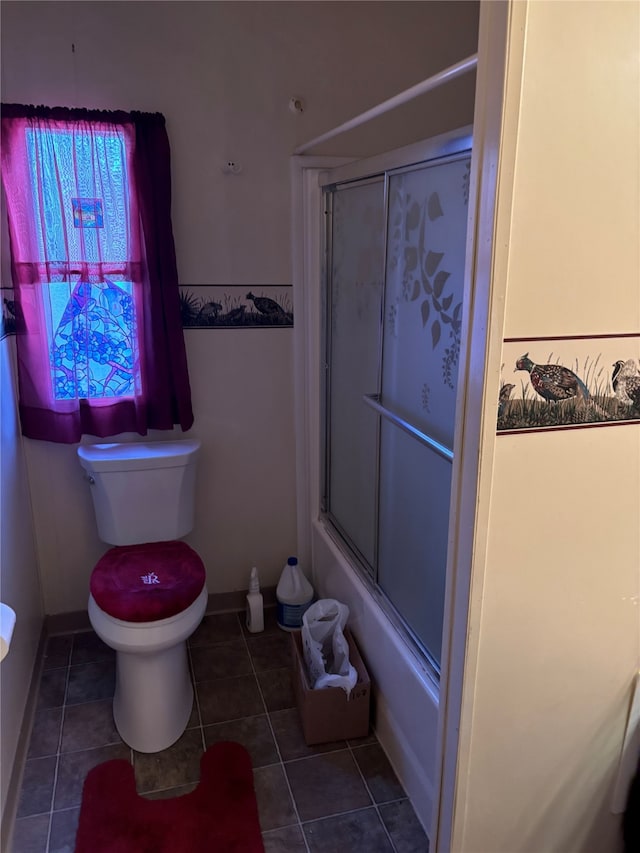 bathroom with enclosed tub / shower combo, toilet, and tile patterned flooring