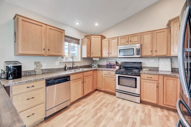 890 Antares Rd, Helena, MT 59602 - kitchen with appliances with stainless steel finishes, light brown cabinetry, lofted ceiling, light wood finished floors, and recessed lighting