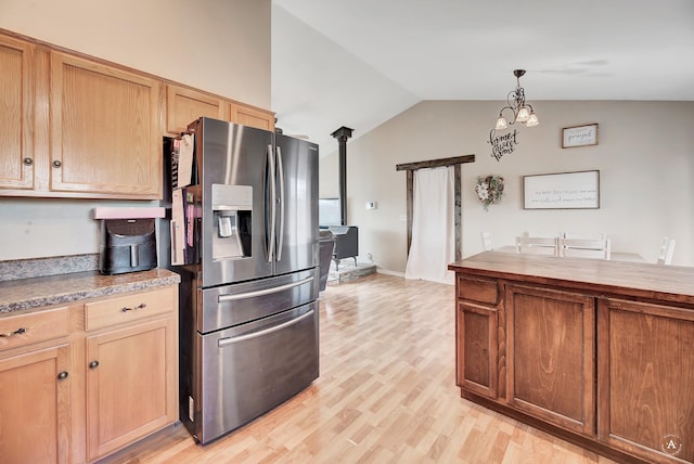 kitchen featuring stainless steel refrigerator with ice dispenser, a notable chandelier, pendant lighting, lofted ceiling, and light wood-type flooring