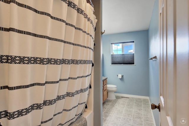 bathroom featuring tile patterned flooring, vanity, toilet, and walk in shower