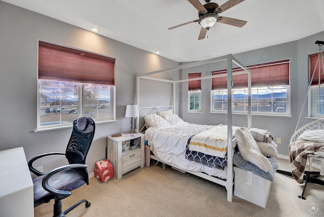 carpeted bedroom with multiple windows and ceiling fan