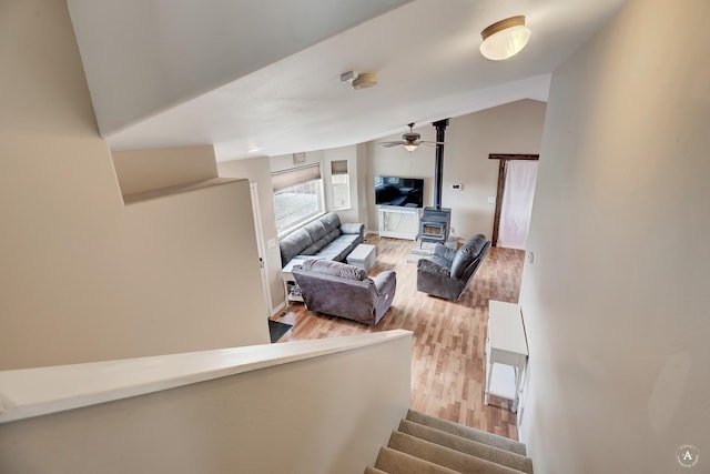 890 Antares Rd, Helena, MT 59602 - living room featuring a wood stove, light wood-style flooring, lofted ceiling, a ceiling fan, and stairs