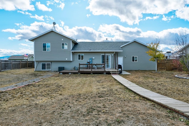 back of property featuring a yard, cooling unit, and a deck