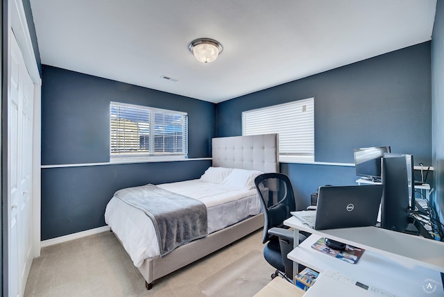 bedroom with light carpet and a closet