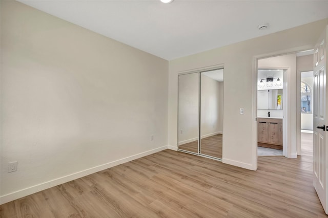 unfurnished bedroom with light hardwood / wood-style floors and a closet