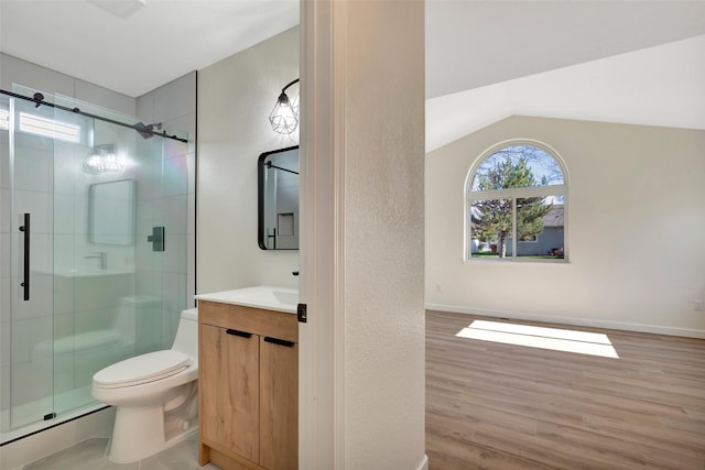 bathroom featuring toilet, wood-type flooring, vaulted ceiling, vanity, and a shower with door