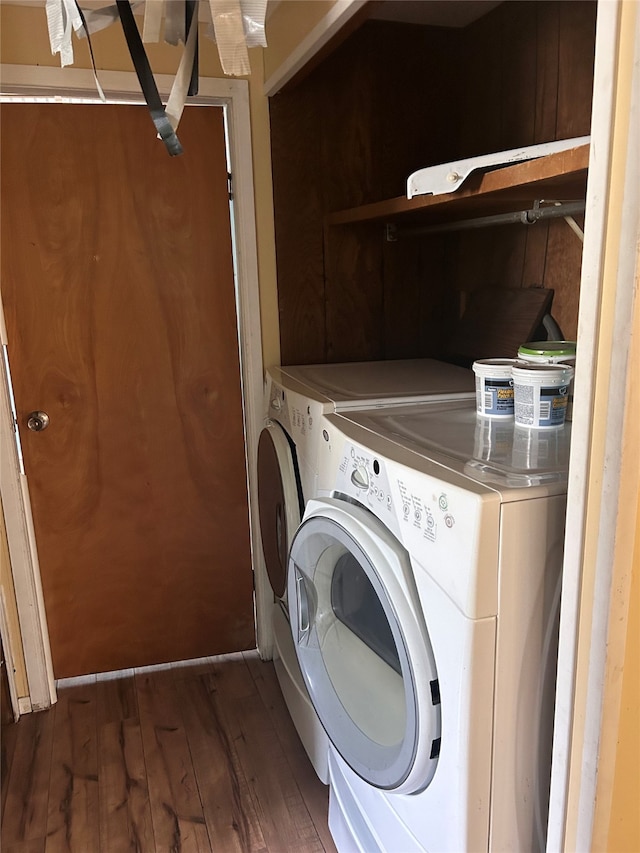 clothes washing area with dark wood-type flooring and washing machine and dryer