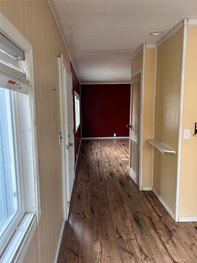 hallway featuring ornamental molding, wood walls, and hardwood / wood-style floors