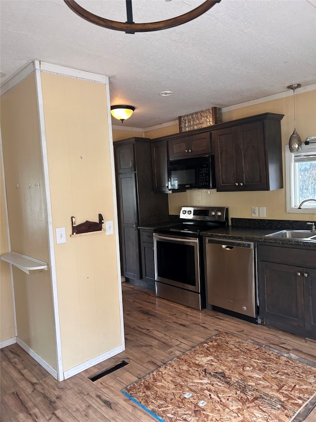 kitchen with sink, dark brown cabinets, stainless steel appliances, crown molding, and hardwood / wood-style flooring