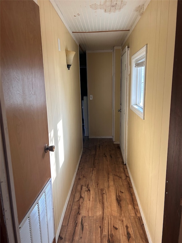 corridor with wooden walls, wood-type flooring, and wooden ceiling