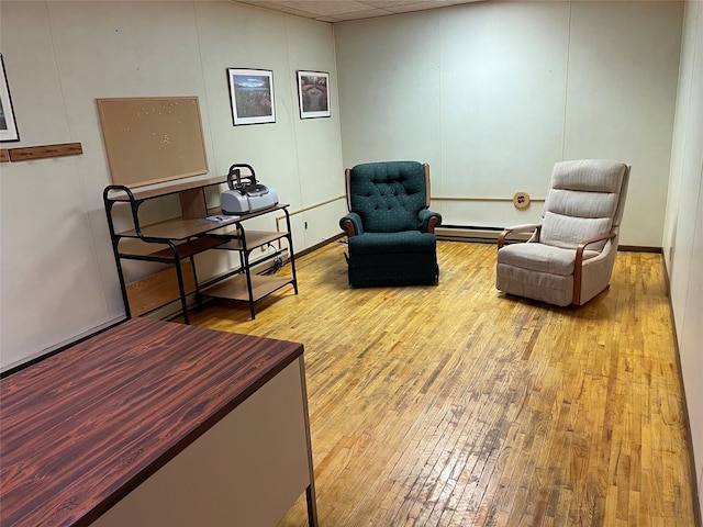 sitting room featuring light hardwood / wood-style flooring and a baseboard heating unit