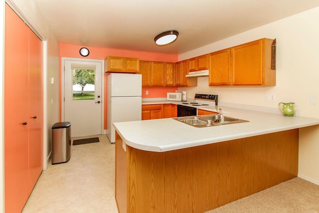 11 Iris Ct, Kalispell, MT 59901 - kitchen featuring white appliances, a sink, a peninsula, light colored carpet, and brown cabinetry