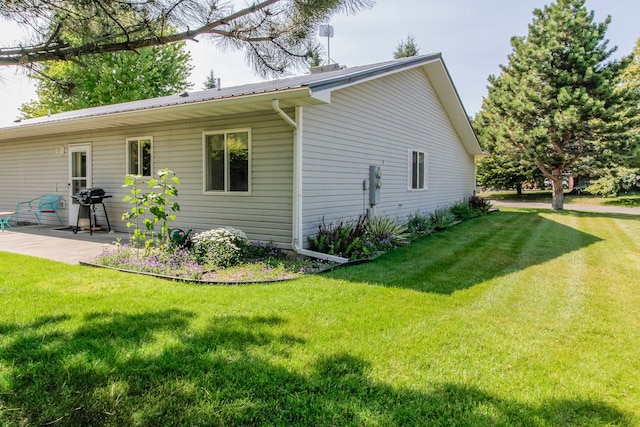 view of home's exterior with a yard and a patio area