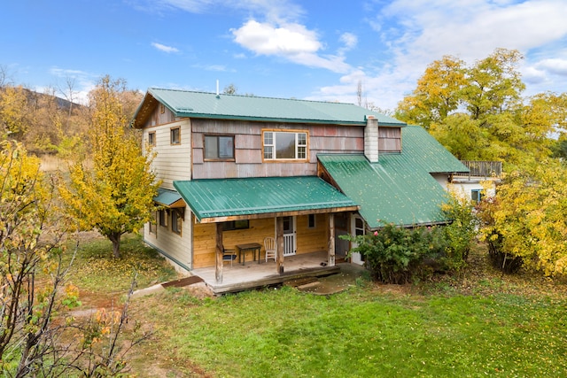 back of property with a porch and a yard