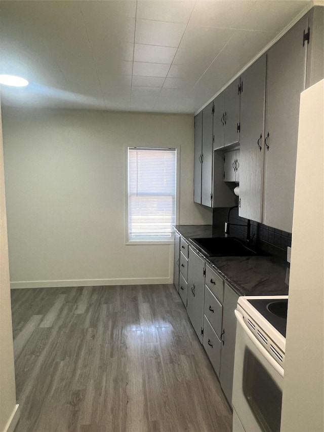 416 2nd St, Deer Lodge, MT 59722 - kitchen with white appliances, dark countertops, dark wood finished floors, a sink, and baseboards