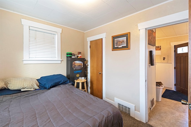 bedroom featuring a closet, ornamental molding, and carpet floors