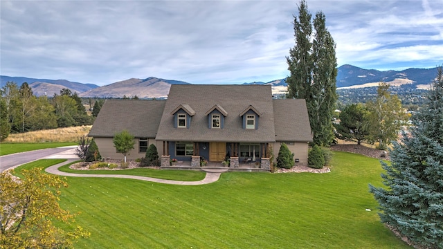 cape cod home with a front yard and a mountain view