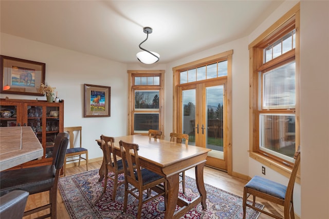 dining space featuring french doors and light hardwood / wood-style flooring