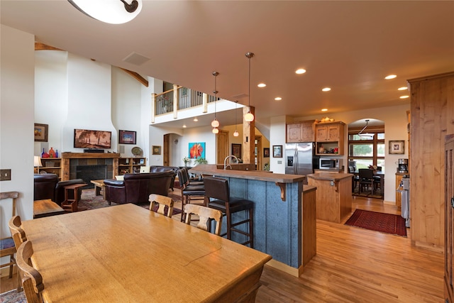 dining space featuring light hardwood / wood-style floors, sink, and a fireplace