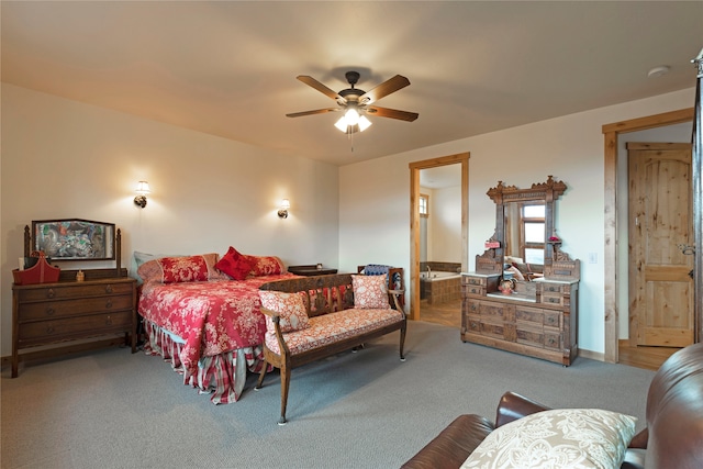 carpeted bedroom with ensuite bathroom and ceiling fan