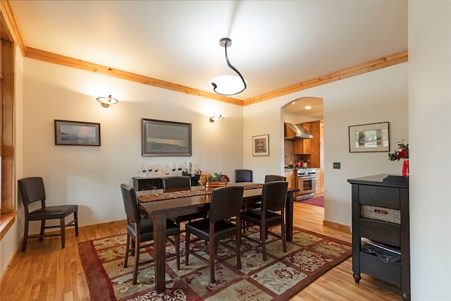 dining space featuring ornamental molding and hardwood / wood-style flooring