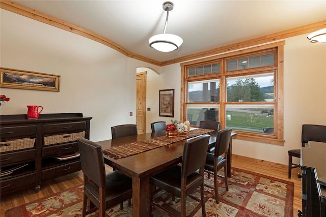 dining area with ornamental molding and hardwood / wood-style floors