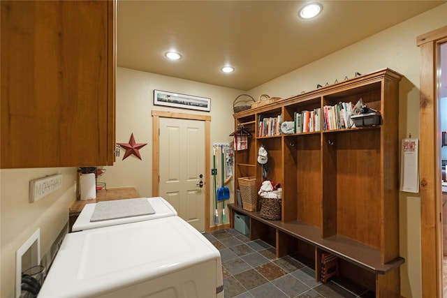 clothes washing area featuring washer and clothes dryer and cabinets