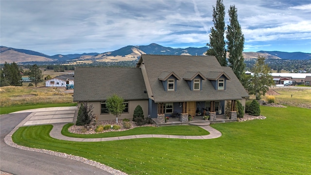 cape cod home with a porch, a mountain view, and a front lawn