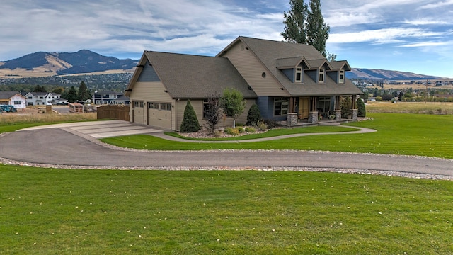 view of front of house with a mountain view, a front yard, and a garage