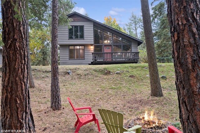 back of property featuring a yard and a wooden deck