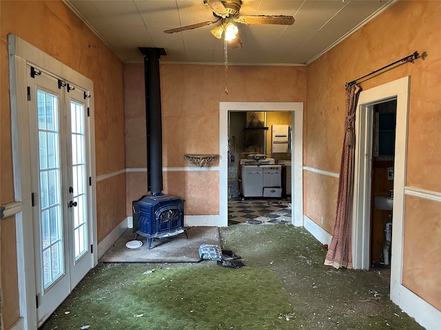 interior space with a wood stove and ceiling fan