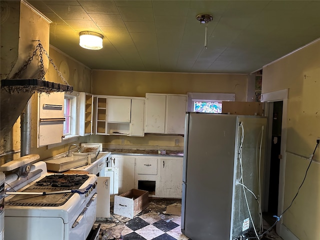 kitchen featuring refrigerator, white gas stove, and white cabinets